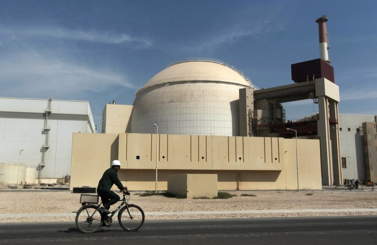 In this Oct. 26, 2010 file photo, a worker rides a bicycle in front of the reactor building of the nuclear power plant, just outside the southern city of Bushehr. (AP)