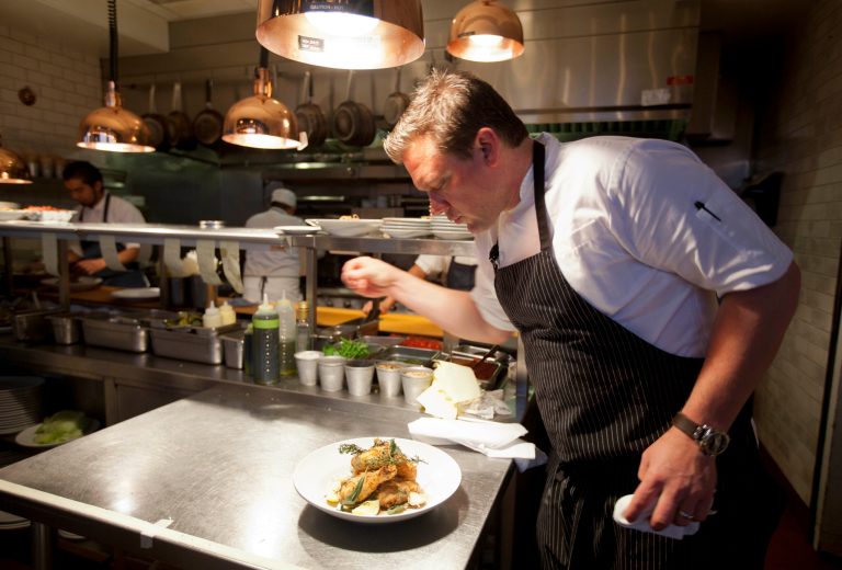   n this photo taken Monday, Oct. 29, 2012, chef Tyler Florence puts a finishing touch to his fried chicken dish in the kitchen at his Wayfare Tavern in San Francisco. Baby food and fried chicken may well be the legacy for which Tyler Florence ultimately is best known. Which seems a bit crazy given his near ubiquity on the Food Network since its earliest days on air, his years of running the celebrity chef gauntlet, his many cookbooks, product lines and appearances. (AP Photo/Eric Risberg)  