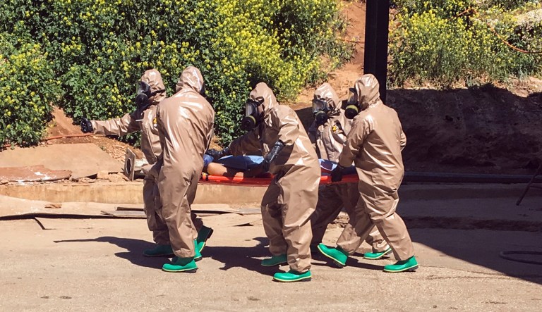 Experts carry a victim of alleged chemical weapons attacks in a Syrian city. The international chemical weapons watchdog confirmed Friday that sarin gas was used in the deadly April attack on a Syria town that left more than 80 people dead. (AP Photo)