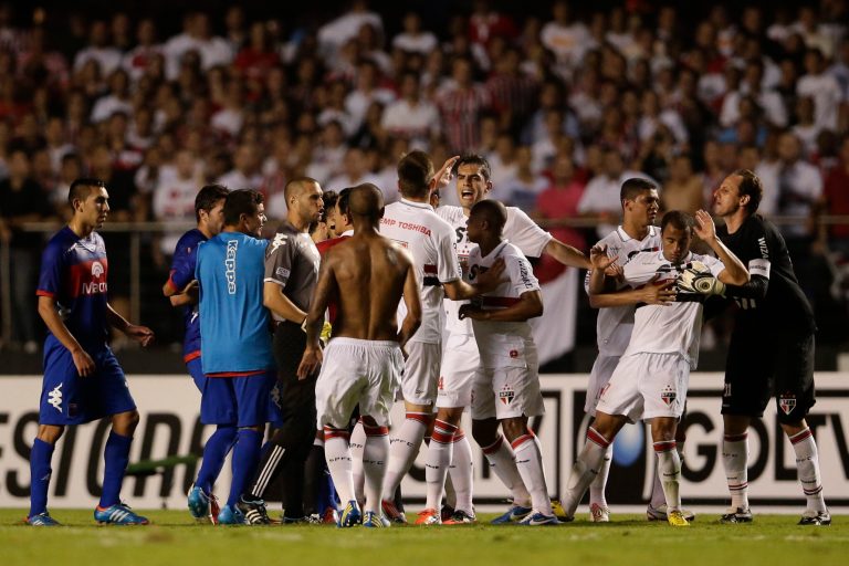   Brazil's Sao Paulo FC's players and Argentina's Tigre's players scuffle at the end of the first half of the Copa Sudamericana final soccer match in Sao Paulo, Brazil, Wednesday, Dec. 12, 2012. (AP Photo/Felipe Dana)  