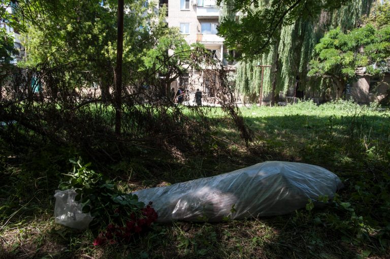 A body lies on the ground near an apartment building damaged by shelling in Mykolaivka, eastern Ukraine, Saturday, July 5, 2014. Ukraine's forces claimed a significant success against pro-Russian insurgents on Saturday, chasing them from one of their strongholds in the embattled east of the country. Rebels fleeing from the city of Slovyansk vowed to regroup elsewhere and fight on.  (AP Photo/Evgeniy Maloletka)