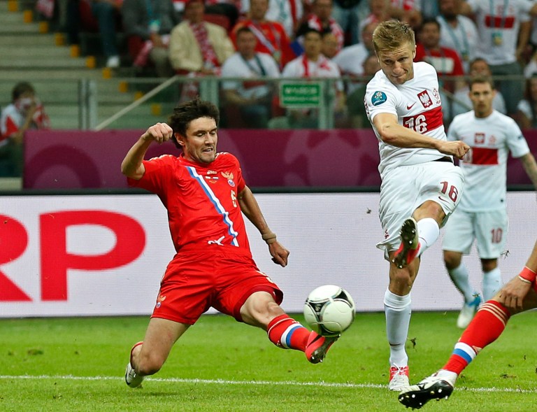   Poland's Jakub Blaszczykowski scores by Russia's Yuri Zhirkov during the Euro 2012 soccer championship Group A match between Poland and Russia in Warsaw, Poland, Tuesday, June 12, 2012. (AP Photo/Matt Dunham)  