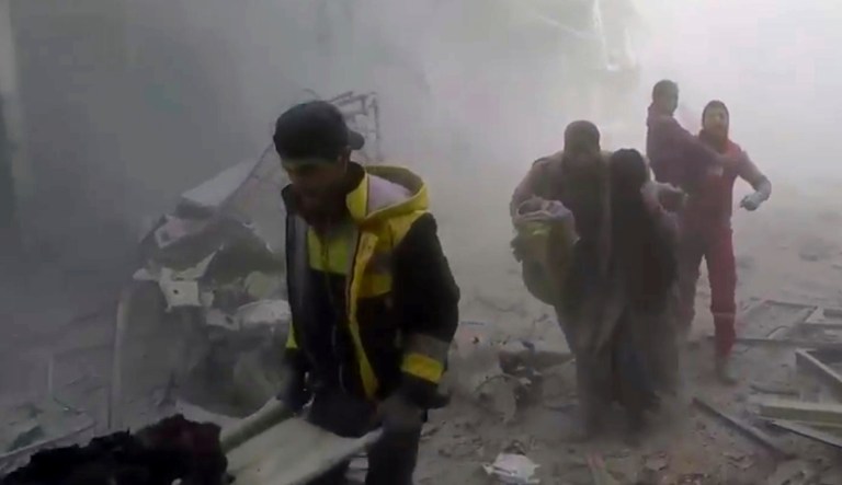 Members of the Syrian Civil Defense group help residents during airstrikes and shelling by Syrian government forces, in Ghouta, a suburb of Damascus, Syria. (Syrian Civil Defense White Helmets via AP)