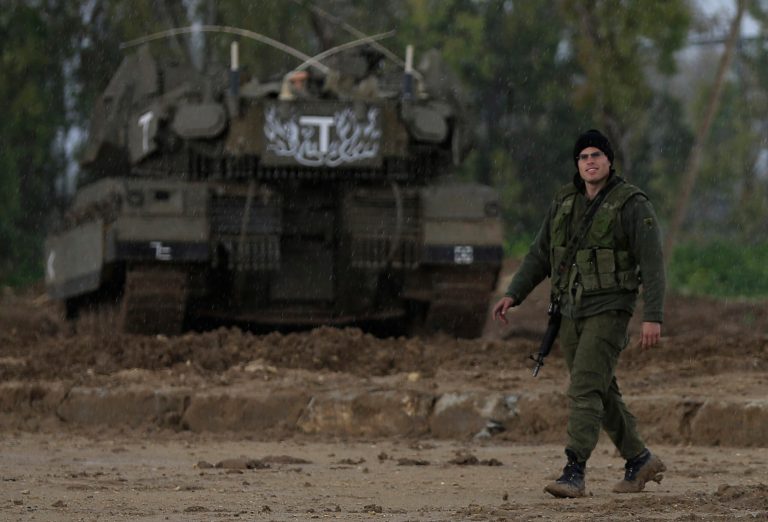An Israeli soldier walks near the Israel and Gaza border on Thursday, March 13, 2014. Gaza militants resumed rocket fire toward Israel on Thursday, striking the outskirts of two major cities a day after launching the largest barrage since an eight-day Israeli offensive in late 2012. Israel has responded with a series of airstrikes on militant targets. (AP Photo/Tsafrir Abayov)