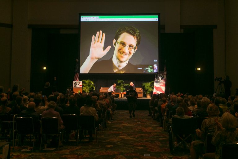NSA leaker Edward Snowden appears on a live video feed broadcast from Moscow at an event sponsored by the ACLU Hawaii in Honolulu on Saturday, Feb. 14, 2015. (AP Photo/Marco Garcia)