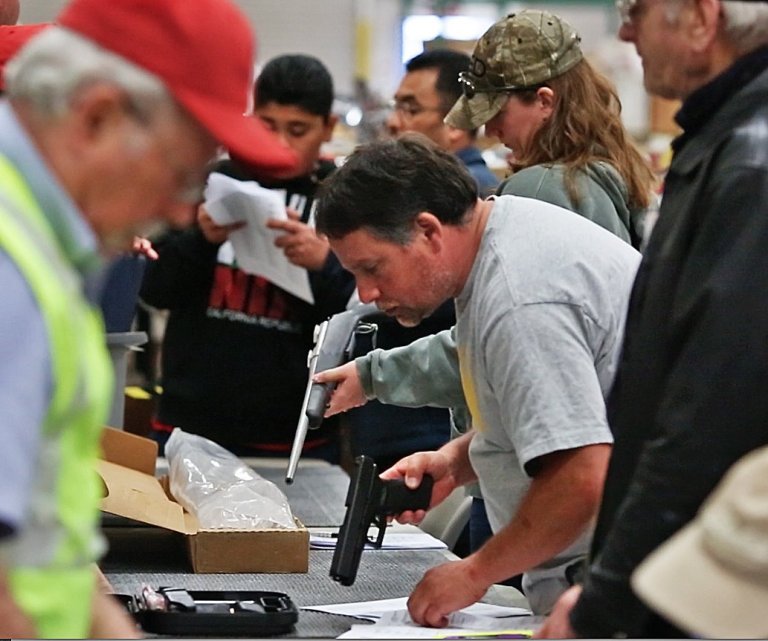 Prospective buyers, above, preview guns for sale at the James G. Murphy Co. auction of Kesselring Gun Shop inventory in Sedro-Woolley, Wash., April 22, 2014. The shop, seen below, was a fixture in Skagit County for decades but had failed for years to comply with federal regulations.  (AP Photo/The Seattle Times, Mark Harrison)