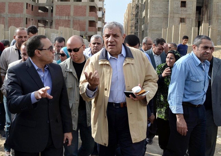 In this Nov. 24, 2013 photo, Ibrahim Mehlib, center, tours a government housing project in Ismailiya, Egypt. Egypt's interim president has chosen as prime minister a construction magnate from the era of ousted autocrat Hosni Mubarak. Adly Mansour on Tuesday, Feb. 25, 2014 named Mehlib, who had for more than a decade led Egypt's biggest construction company, Arab Contractors, to replace Hazem el-Beblawi, who resigned on Monday.(AP Photo/Khaled Kandil)