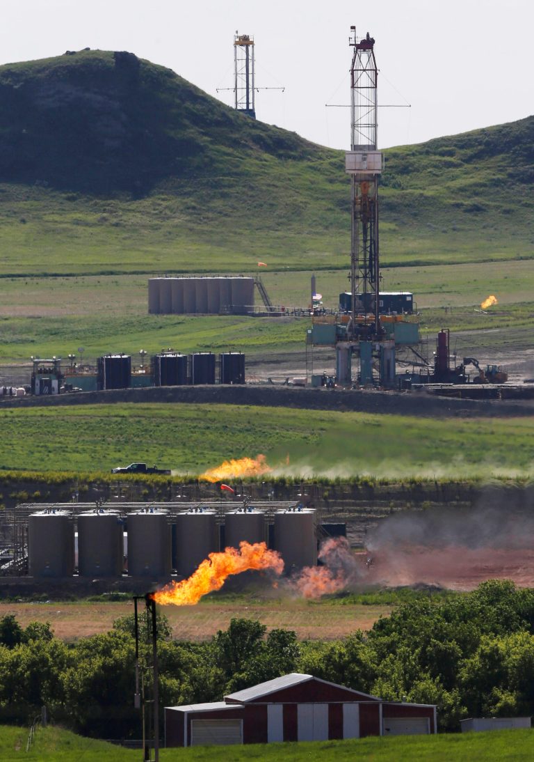 FILE - In this June 9, 2014 file photo, natural gas is flared at an oil production facility in Watford City, N.D. North Dakota's unprecedented oil bonanza has boosted salaries throughout the state, though the male-dominated, high-paying energy industry also is widening the wage gap between men and women, the state's demographer said.  (AP Photo/Charles Rex Arbogast, File)