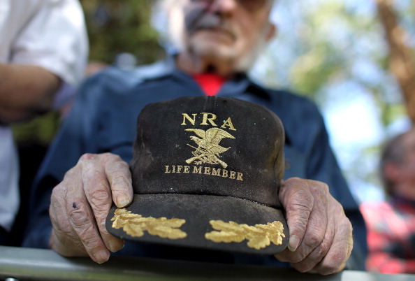 CRAIG, CO - MAY 29:  A supporter of Republican presidential candidate, former Massachusetts Gov. Mitt Romney holds an NRA baseball cap during the singing of the National Anthem at a campaign rally at Alice Pleasant Park on May 29, 2012 in Craig, Colorado. Mitt Romney will campaign in Colorado and Las Vegas, Nevada.  (Photo by Justin Sullivan/Getty Images)
