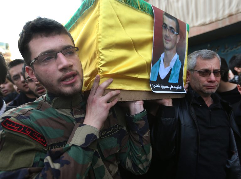 The father, right, and brother of Ali Khadra, left, who was killed Thursday by a bomb explosion, carry his coffin during his funeral procession in the southern suburb of Beirut, Lebanon on Saturday. (AP Photo/Hussein Malla)