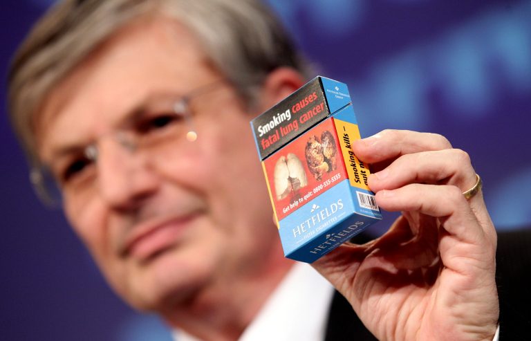   European Commissioner for Health and Consumer Policy Tonio Borg holds up a mock package of cigarettes during a news conference on proposals to revise the Tobacco Products Directive, at the European Commission headquarters in Brussels, Wednesday, Dec. 19, 2012. (AP Photo/Yves Logghe)  