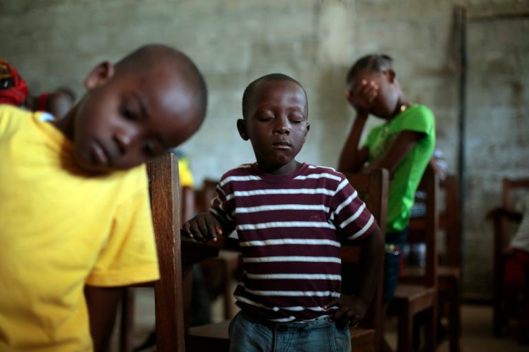 Children pray during Sunday service at the Bridgeway Baptist Church in the St. Paul Bridge neighborhood of Monrovia, Liberia. (AP/Jerome Delay)