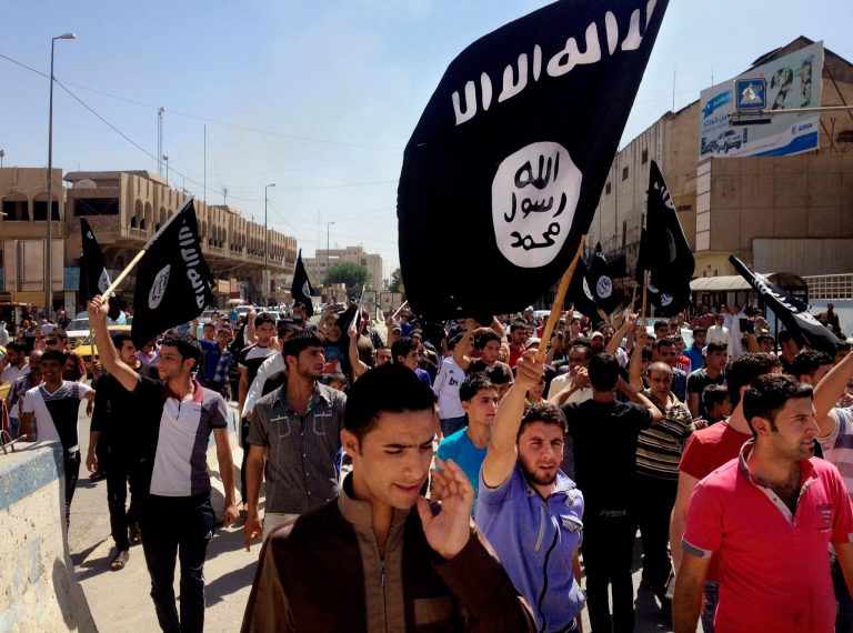 Demonstrators chant pro-Islamic State group slogans as they carry the group's flags in front of the provincial government headquarters in Mosul, 225 miles northwest of Baghdad, in this June 16, 2014 file photo. (AP Photo, File)