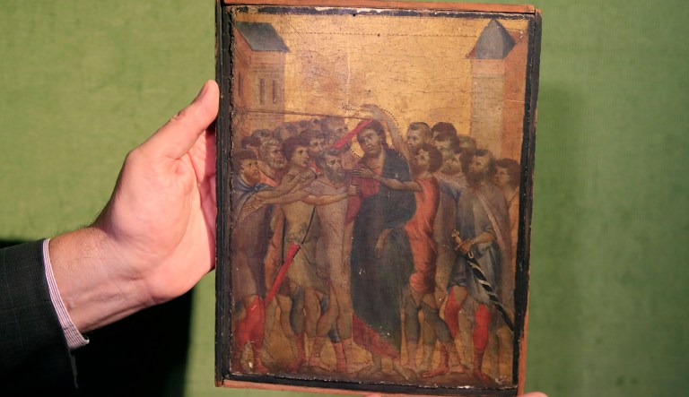 Art expert Stephane Pinta points to a 13th century painting by Italian master Cimabue in Paris, Tuesday, Sept. 24, 2019. A rare 13th century painting by Italian master Cimabue has been found in a French kitchen, and is now expected to fetch millions of euros at an upcoming auction.