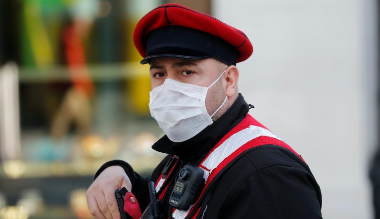 A Security officer with a face mask patrols in London, Tuesday, March 24, 2020. Britain's Prime Minister Boris Johnson on Monday imposed its most draconian peacetime restrictions due to the spread of the coronavirus on businesses and social gatherings.
