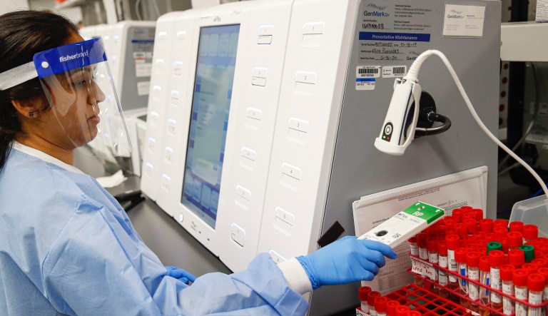 A laboratory technician prepares COVID-19 patient samples for semiautomatic testing at Northwell Health Labs, Wednesday, March 11, 2020, in Lake Success, New York. 
