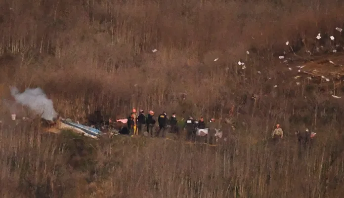 A body is moved from the scene of a helicopter crash that killed former NBA basketball player Kobe Bryant in Calabasas, Calif., Sunday, Jan. 26, 2020.