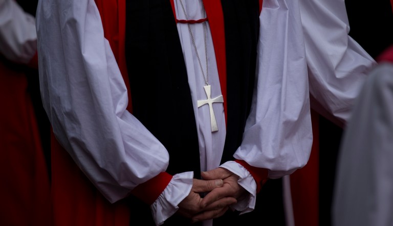 A cross is worn by a religious representative lined up to enter Canterbury Cathedral for the enthronement ceremony of Britain's new Archbishop of Canterbury Justin Welby in Canterbury, England, Thursday, March 21, 2013.