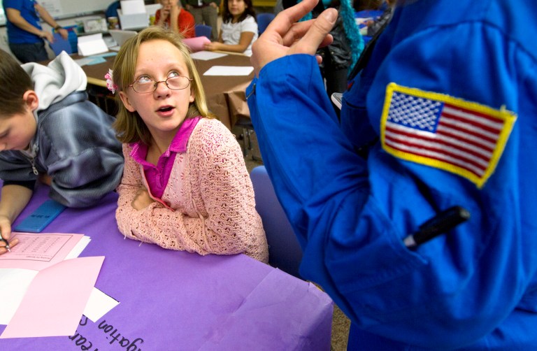   Hillcrest Elementary fifth-grader Sarah VanGrundy speaks to Commander Michelle Wallace of the Challenger Learning Center Monday, Dec. 17, 2012 in Gillette, Wyo., during an exercise in which the fifth-grade class had to solve math and science problems to find a missing satellite. Wallace, who was a former math teacher, has been with the The Challenger Learning Center for over a year. It's purpose is to expose and inspire young students about the real world applications of math and science in a practical setting. (AP Photo/Gillette News-Record, Eric Ginnard)  