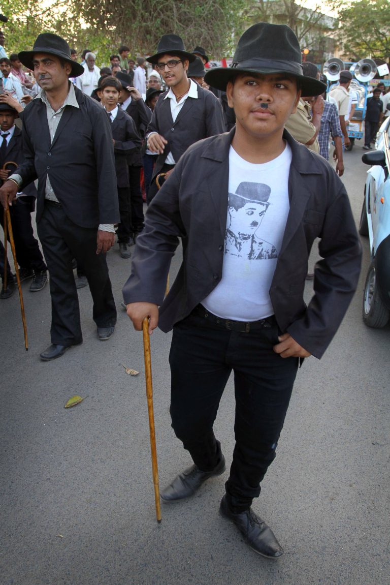 Members and supporters of the Charlie Circle, a Charlie Chaplin fan-club, participate in an annual parade to celebrate the birthday of Charlie Chaplin in Adipur, Gujarat state, India, Tuesday, April 16, 2013. Canes in hand and bowler hats firmly in place, dozens of Charlie Chaplin impersonators tramped through the streets of this small port town in western India on Tuesday to celebrate the birthday of the legendary comic actor and filmmaker. (AP Photo/Ajit Solanki)