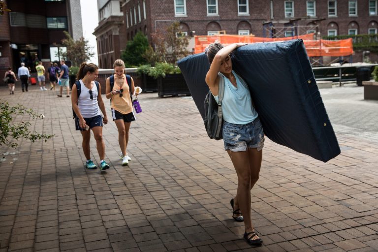 Emma Sulkowicz carries a mattress in protest of the university's lack of action after she reported being raped during her sophomore year. (Photo by Andrew Burton/Getty Images)
