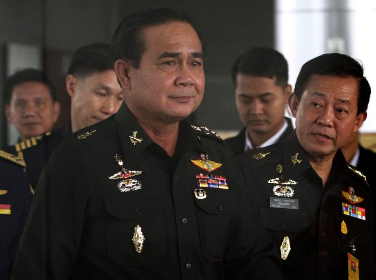 FILE - In this June 13, 2014 file photo, Thailand's Army commander Gen. Prayuth Chan-ocha, left, arrives at the Royal Thai Army Club in Bangkok, Thailand. Critics and journalists raised concerns Saturday, July 19, 2014 about the Thai military government's latest move to tighten its grip on the media by banning them from criticizing the junta's operations and threatening to immediately suspend the broadcast or publication of content that defies the order. Critics said the order to censor all forms of media was expansive and contradicted the message the coup leader, Gen. Prayuth, has attempted to send to the Thai people. (AP Photo/ASTV Manager newspaper, File) THAILAND OUT