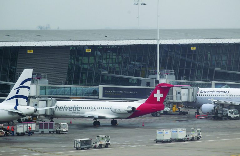 Baggage carts make their way past a Helvetic Airways aircraft from which millions' of dollars worth of diamonds were stolen on the tarmac of Brussels international airport, Tuesday, Feb. 19, 2013. Eight armed and masked men made a hole in a security fence at Brussels' international airport, drove onto the tarmac and snatched millions of dollars' worth of diamonds from the hold of a Swiss-bound plane without firing a shot, authorities said Tuesday. (AP Photo/Yves Logghe)