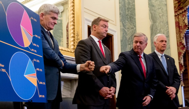 Sen. Bill Cassidy, R-La., left, and Sen. Lindsey Graham, R-S.C., fist bump after unveiling legislation to reform healthcare. They were accompanied by Sen. Dean Heller, R-Nev., and Sen. Ron Johnson, R-Wis. CBO said it would provide a 