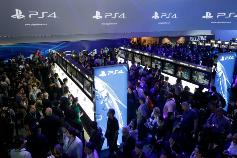 FILE - In this June 11, 2013 file photo, show attendees play video games on the new Sony PlayStation 4 at the Sony booth during the Electronic Entertainment Expo, in Los Angeles. With the launch of the Xbox One, PlayStation 4 and Wii U in the video game industry's rearview mirror, the spotlight at the Electronic Entertainment Expo, held June 10-12, 2014, is expected to shift back to games. From online-only titles to virtual reality experiences, about 200 exhibitors will hype their latest software in hopes of driving away from E3 with The Next Big Thing. (AP Photo/Jae C. Hong, file)