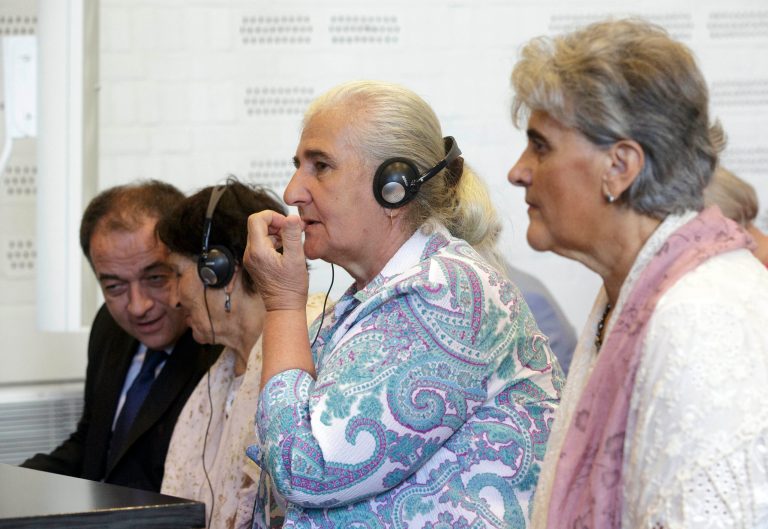 Women from the Bosnian town of Srebrenica wait for judges to enter a civil court in The Hague, Netherlands, Wednesday, July 16, 2014. A Dutch court has declared the country liable in the deaths of more than 300 Bosnian Muslim men murdered by Bosnian Serb forces in the United Nations-declared Srebrenica 