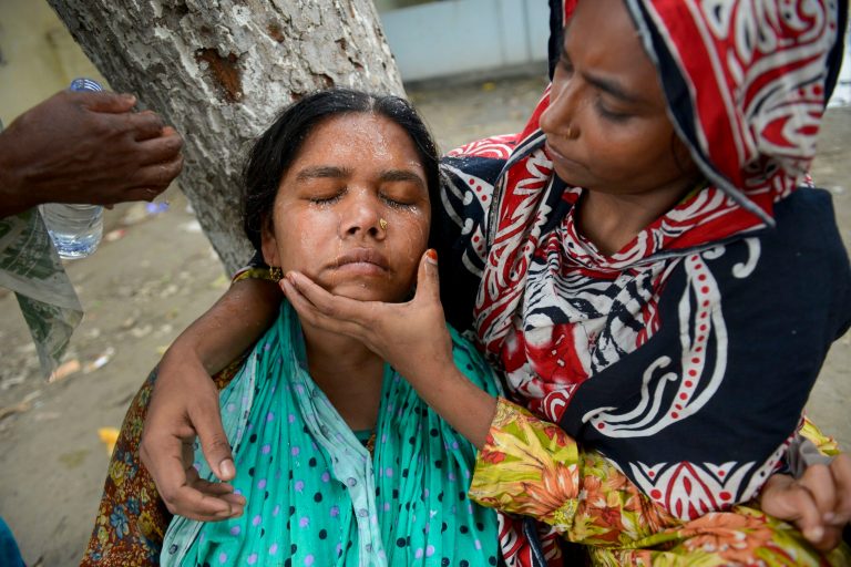 A woman faints after weeping for hours near the rubble of the eight-story Rana Plaza building that collapsed in Savar, near Dhaka, Thursday, May 9, 2013. The death toll from the collapse of the garment factory building passed 900 on Thursday even as a fire in an 11-story garment factory Wednesday night in Dhaka killed eight people, including a ruling-party politician and a top official in the country's powerful clothing manufacturers' trade group. (AP Photo/Ismail Ferdous)