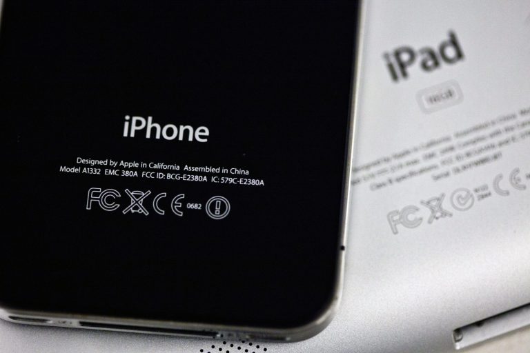   The back of an iPhone 4 and IPad 3 are displayed for a photographer in New York, Thursday, Dec. 6, 2012. Apple CEO Tim Cook said Thursday the company will produce one of its existing lines of Mac computers in the United States next year. Like most consumer electronics companies, Apple forges agreements with contract manufacturers to assemble its products overseas. (AP Photo/Karly Domb Sadof)  