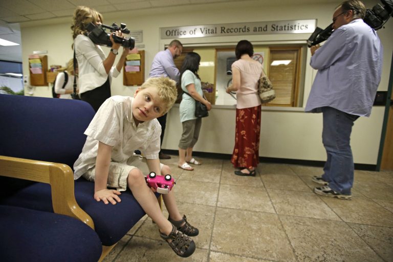 FILE - In a Tuesday, July 8, 2014 file photo, Annette Maughan, of Cedar Hills, center back, stands in line at the Utah Department of Health, while her 11-year-old son Glenn, who has a form of epilepsy, sits in the waiting room in Salt Lake City.  St. George Republican State Sen. Steve Urquhart says Utah could ease the burden for families participating in the state's limited medical marijuana program by selling a cannabis extract in state liquor stores. Under the program approved by Gov. Gary Herbert earlier this year, Utah residents with severe epilepsy are allowed to possess the low-potency extract, but Utah law doesn't allow the production or distribution of the extract oil.  (AP Photo/Rick Bowmer, File)