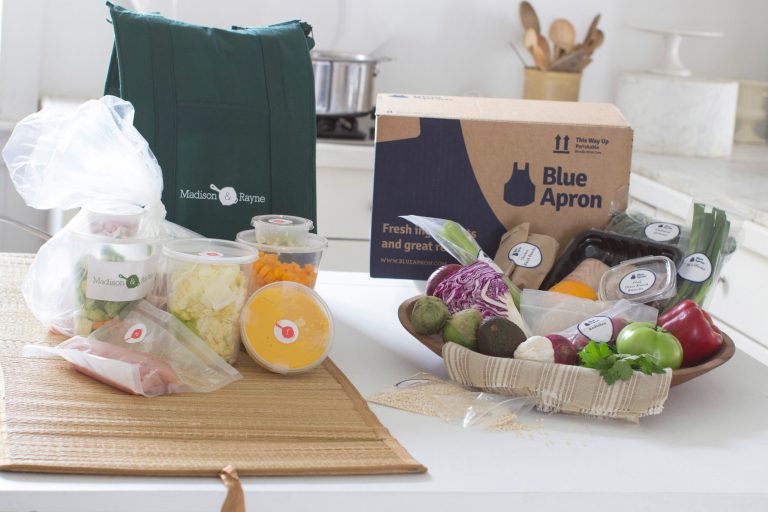 This Oct. 6, 2014 photo shows an example of home delivered meals from Madison & Rayne (on left) and Blue Apron in Concord, N.H. A bevy of new online services is angling to be a virtual kitchen assistant, giving the chance to outsource the tedious aspects of cooking so that customers can focus on the more satisfying assembling and eating parts. (AP Photo/Matthew Mead)
