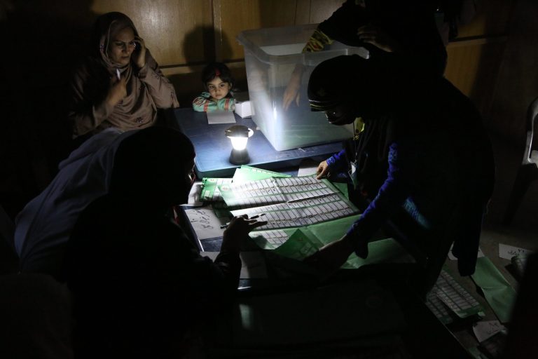 FILE - In this Saturday, April 5, 2014, file photo, Afghan election workers count ballots by the light of a lantern at a polling station in Jalalabad, east of Kabul, Afghanistan. Afghanistan is to release preliminary results in its crucial presidential election on Saturday, but the results are only one step in a potentially long road to determine who will succeed President Hamid Karzai. Neither Abdullah Abdullah, a former foreign minister, nor ex-finance minister Ashraf Ghani Ahmadzai look set to win a majority, meaning the violence-weary country could be heading for a runoff.  (AP Photo/Rahmat Gul, File)