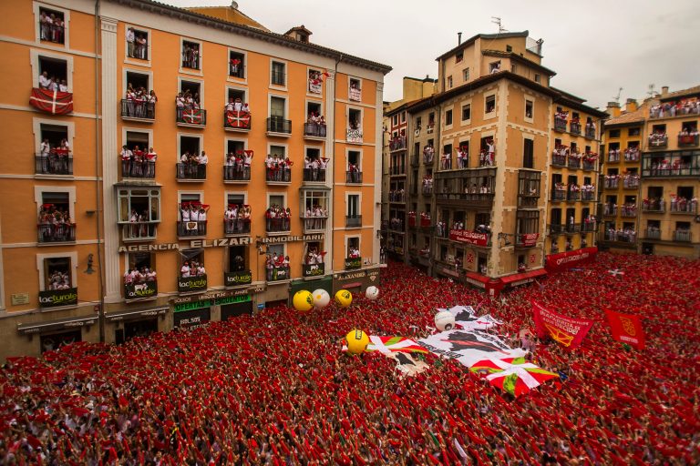 Revelers hold up traditional red neckties during the launch of the 