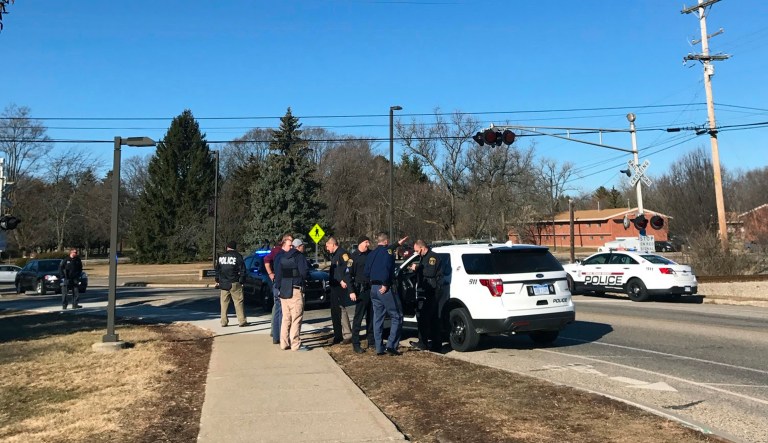 Authorities stand on the campus of Central Michigan University during a search for a suspect, in Mount Pleasant, Mich. School officials say police are responding to a report of shots fired at a residence hall at the university. (Lisa Yanick Litwiller/The Morning Sun via AP)