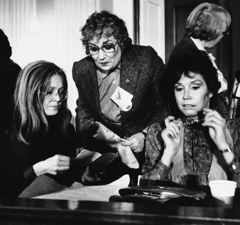 Women's rights activist Gloria Steinem, left, joins former Rep. Bella Abzug and actress Mary Tyler Moore, right, during a meeting of women's rights leaders on Capitol Hill, Feb. 4, 1981 in Washington. (AP Photo/John Duricka)