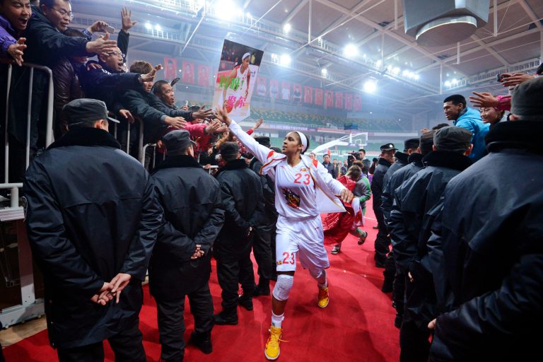   In this Nov. 24, 2012, photo, Shanxi Flame's Maya Moore greets fans as she prepares to take the court for a WCBA basketball game against the Jiangsu Dragons in Taiyuan, China. While her Minnesota Lynx team awaits the return of WNBA training camp in May, Moore is averaging 45 points a game and earning mid-six figures for the Flame, helping bring new fans to the women's game in a baseball crazed nation. (AP Photo/CHINATOPIX) CHINA OUT  
