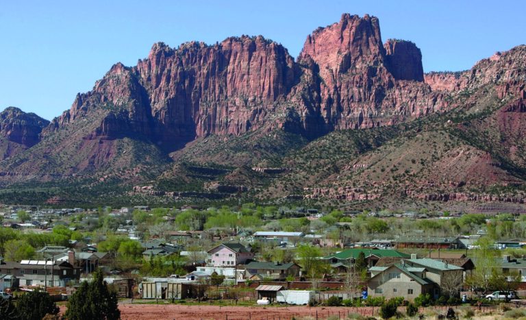 FILE - Hildale, Utah sits at the base of red rock cliff mountains with its sister city, Colorado City, Ariz., in the foreground in this Thursday, April 20, 2006, file photo. A federal appeals court ruled Monday, Nov. 5, 2012, that the polygamist sect on the Utah-Arizona border waited too long to challenge a court-ordered takeover, clearing the way for state authorities to break up a church trust and sell assets including homes, businesses and farms in two small towns. A three-judge panel of the 10th U.S. Circuit Court of Appeals overturned a federal judge in Salt Lake City, who ruled nearly two years ago that Utah's takeover violated the constitutional rights of the Fundamentalist Church of Jesus Christ of Latter-Day Saints. (AP Photo/Douglas C. Pizac, File)