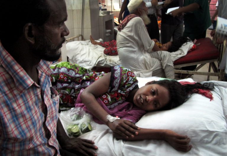 Merina, a survivor of the garment factory building collapse, is comforted by her father in hospital on Saturday April 27, 2013 in Savar, near Dhaka, Bangladesh. Merina was trapped under rubble for three days, surviving with nothing to eat and only a few sips of water. The building collapse was the worst disaster to hit Bangladesh's $20 billion a year garment industry.(AP Photo/Gillian Wong)