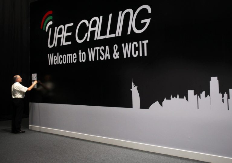   FILE-In this file photo dated Monday, Dec. 3, 2012, an official sticks a note on the wall next to the conference banner during the eleventh day of the World Conference on International Telecommunication in Dubai, United Arab Emirates. A U.N. conference weighing possible Internet rules shifted into high-stakes showdowns on Thursday after advancing a proposal for greater government oversight. The proposal was a blow to U.S.-led efforts to keep new regulations from touching the Net. (AP Photo/Kamran Jebreili, File)  