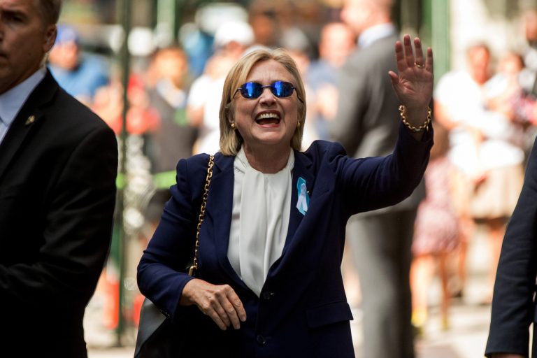 Democratic presidential candidate Hillary Clinton waves after leaving an apartment building Sunday, Sept. 11, 2016, in New York. Clinton's campaign said the Democratic presidential nominee left the 9/11 anniversary ceremony in New York early after feeling 
