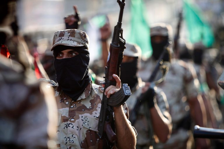 Masked Palestinian members of the military wing of Hamas carry their weapons while chanting slogans during a parade to mark the anniversary of a 2012 battle against Israel in Gaza City. (AP Photo/Adel Hana)