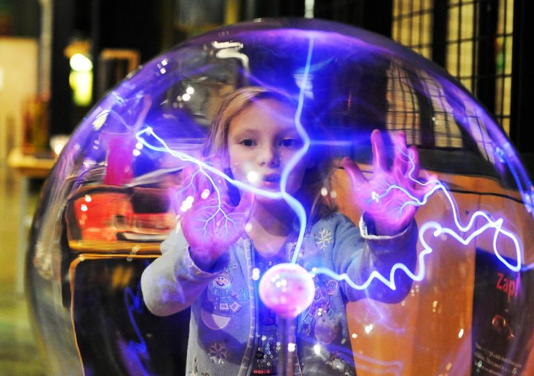   Nastia Karpov, 6, is fascinated as energy is attracted to her hands in a large plasma globe, one of the exhibits children and photographers are often attracted to at the science center, in Detroit, Wednesday, Dec. 26, 2012. Michigan Science Center which reopened to the public today after more than a year of being closed because of financial mismanagement. (AP Photo/The Detroit News, Daniel Mears)  