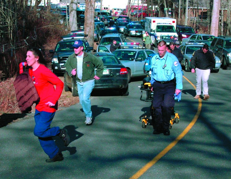 FILE - In this Dec. 14, 2012 file photo provided by the Newtown Bee, paramedics and others rush toward Sandy Hook Elementary School in Newtown, Conn., shortly after Adam Lanza opened fire, killing 26 people, including 20 children. While the people of Newtown do their best to cope with loss and preserve the memories of their loved ones, another class of residents is also finding it difficult to move on: the emergency responders who saw firsthand the terrible aftermath of last week's school shooting. (AP Photo/Newtown Bee, Shannon Hicks, File) MANDATORY CREDIT: NEWTOWN BEE, SHANNON HICKS