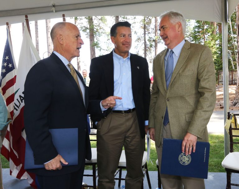 California Gov. Jerry Brown, left, talks with Nevada Gov. Brian Sandoval, center, and Rep. Tom McClintock, R-Calif., after they spoke a the 18th Annual Lake Tahoe Summit, Tuesday, Aug. 19, 2014, in South Lake Tahoe, Calif.  McClintock, whose district includes the west side of Lake Tahoe, said that money from logging could help pay for forest improvements. (AP Photo/Rich Pedroncelli)