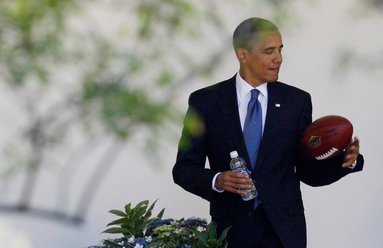 FILE - In this  Thursday, May 21, 2009,  file photo, President Barack Obama plays with a football as he walks back to the Oval Office of the White House in Washington. Concerned that too little is known about the effects of head injuries in young athletes, President Barack Obama is bringing representatives of professional sports leagues, coaches, parents, youth sports players, researchers and others to the White House Thursday, May 29, 2014, to help educate the public about youth sports concussions. (AP Photo/Charles Dharapak, File)