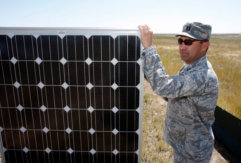 In this photo taken on Friday, Aug. 28, 2009, U.S. Army Capt. Javier Abarca, chief of maintenance, holds one of the 5,040 solar panels that will be installed as part of a solar energy farm on Buckley Air Force Base in Aurora, Colo. (AP File)