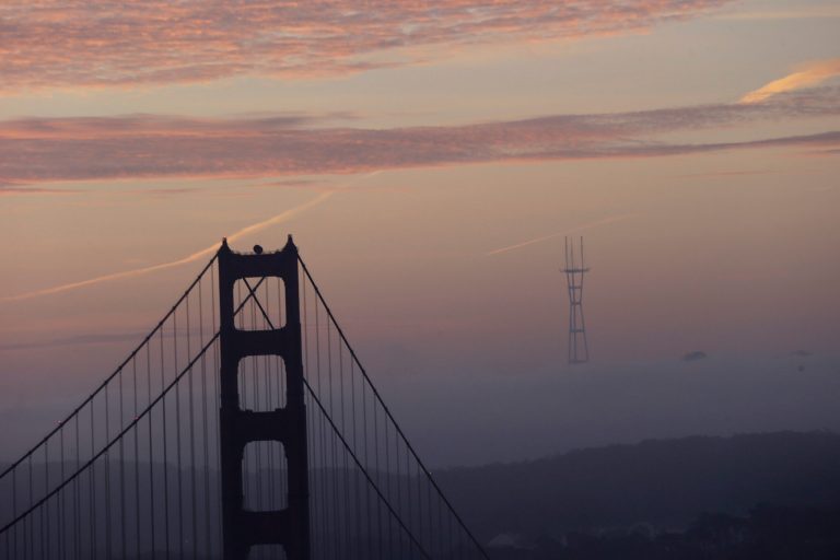 The Golden Gate Bridge towers over the fog-covered city at sunrise in San Francisco. (AP/Marcio Jose Sanchez)